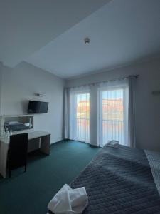 克拉科夫波勒斯基酒店的酒店客房设有一张床、一张书桌和窗户。
