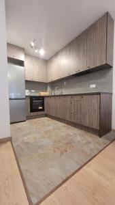斯维德尼克Apartament "Cztery Pory Roku"的一个带木制橱柜和不锈钢冰箱的大厨房