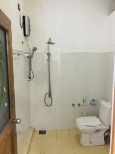 波隆纳鲁沃Hotel Siyathma polonnaruwa的带淋浴和卫生间的浴室以及电话。