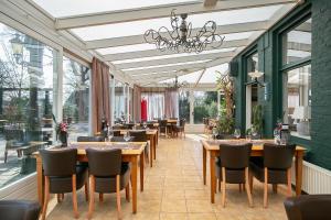 瓦普斯德瓦普赛赫伯格酒店的用餐室设有桌椅和窗户。