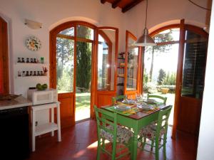 因普鲁内塔Villetta Lilla'的一间厨房,里面配有绿色的桌子和椅子