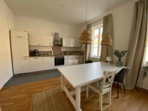 拜罗伊特Wohnung in Bayreuths schönster Straße的白色的厨房配有白色的桌子和椅子