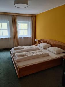 瓦格赖恩Pension Reiterhaus的配有两张床铺的黄色墙壁和两扇窗户
