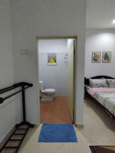 珍南海滩Dahliya Roomstay Langkawi的浴室设有1间带卫生间和1张床的卧室