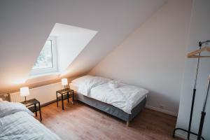门兴格拉德巴赫Working Apartment - 8 single beds - 5 Schlafzimmer的阁楼卧室配有两张床和两盏灯。