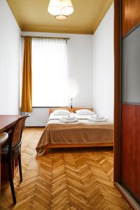 克拉科夫Top Location Apartments Topolowa Street的一间卧室配有一张床、一张书桌和一个窗户。
