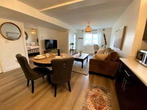 维多利亚Cozy Lakeview Suite的一间带桌椅的客厅和一间客厅。