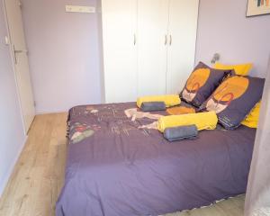 里昂Le Monplaisir - T2 Cosy - Proche du métro的一间卧室配有一张带黄色枕头的大床