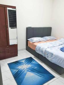 哥打丁宜DAN'S Homestay Business Suite Home的一间卧室配有一张床和蓝色地毯