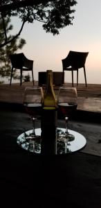 TamaniqueCabaña Tamanique的桌子上放有一瓶葡萄酒和两杯酒