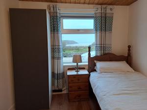 MountcharlesBlaneys Coastal Cottage的一间卧室设有一张床和一个大窗户