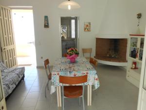 莱乌卡Casa Raffaele的一间带桌子和壁炉的用餐室