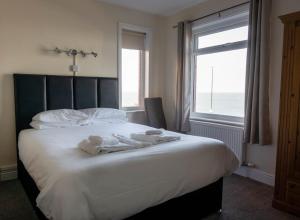 惠特比威尔戴尔旅馆的一间卧室配有一张大床和毛巾
