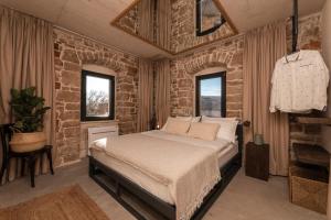 Gornji HumacShe House - built for pleasure - Island of Brač的一间卧室设有一张床和砖墙