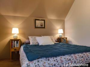 滨海图维列Du coté de chez Swann 1的一间卧室配有一张带蓝色床单的床和两盏灯。