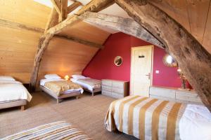 Le chant des pierres - douceur et nature的阁楼卧室设有两张床和红色的墙壁