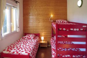 奥特朗Gîte CAMPANULES - 5 personnes - "Les Gites du Chalet" à Autrans的一间卧室设有红色双层床和窗户。