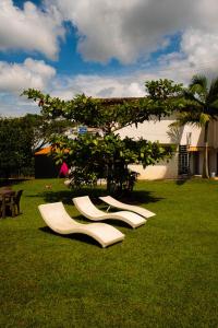 金巴亚Finca Hotel San Angello的一组坐在草地上的白色椅子