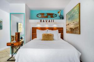 科纳DOWNTOWN HAWAIIAN PARADISE HOTEL CONDO with Hot Tub, Pool & Beach的卧室配有一张白色大床和一张书桌