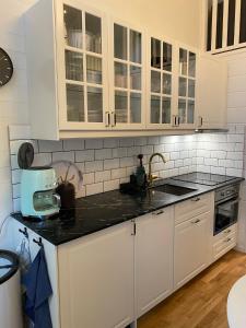 韦姆达伦Stuga i Vemdalen的厨房配有白色橱柜和黑色台面