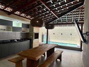 塔曼达雷Casa Praia dos Carneiros的一个带木桌和长凳的大厨房