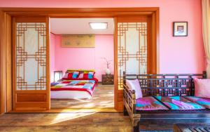 束草市卡萨西拉克住宿加早餐旅馆的一间卧室设有两张床,墙壁粉红色