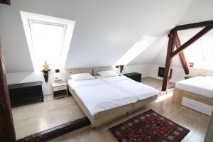 卢布尔雅那卡特卡酒店的一间卧室设有一张大床和两个窗户。
