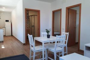 格罗韦Casa rural en San Vicente de O Grove的一间设有白色桌子和白色椅子的用餐室