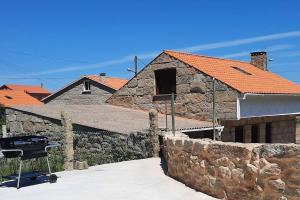 格罗韦Casa rural en San Vicente de O Grove的一座带石墙和烧烤架的房子