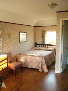 卡文迪西埃文利亚小屋酒店的一间卧室配有一张大床和一把椅子