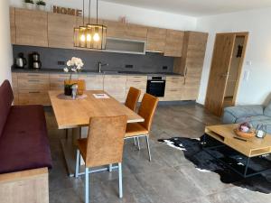米特西尔Ferienwohnung Traumblick -Familie Seber的厨房以及带木桌和椅子的客厅。