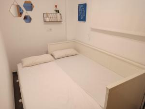 法罗德卡勒拉Precioso apartamento en el Faro de Cullera的小房间,配有床和两个枕头