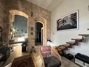 耶路撒冷נרקיס NARKIS的客厅设有石墙、椅子和钢琴