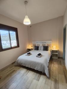托洛克斯Casa Rural Sierra De Las Nieves的卧室设有一张白色大床和一扇窗户。