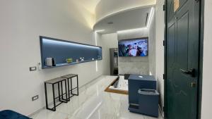 巴勒莫I Cappuccini Suite的浴室设有电视、两张凳子和一扇门