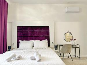 萨格勒布Bed & Breakfast Donji Grad的一间卧室配有一张大床和紫色床头板