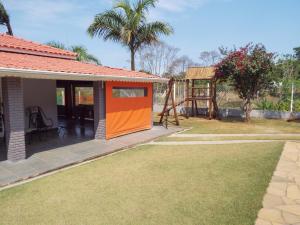 皮尼亚尔齐纽Chácara Recanto da Paz的院子里房子的橙色门
