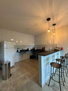 伦索伊斯Casas do Serrano的厨房配有柜台、一些椅子和冰箱