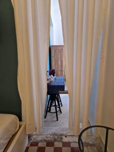 特拉尼B&B Porto Trani的一间设有白色窗帘和桌椅的房间