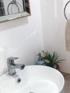 洛斯安赫莱斯Departamento Los Canelos, a metros de Avenida Las Industrias, incluye aire acondicionado的浴室设有白色水槽和镜子