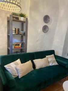 奥尔维拉Acogedora casa rural en Olvera ,La Morada的客厅配有带枕头的绿色沙发