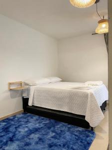 麦德林Selvática Alojamiento Eco的一间带两张床的卧室和蓝色地毯