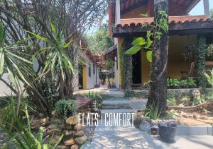 圣若热岛NOVIDADE FLATS COMFORT na Vila de São Jorge - Chapada dos Veadeiros的一座带树木和植物的庭院的房子