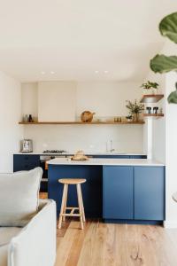 Stokes BayStowAway Kangaroo Island的厨房配有蓝色橱柜和木凳