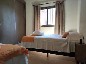 查克拉斯德科里亚Entre Uvas y Siestas - Casa Álamos的一间卧室设有两张床和窗户。