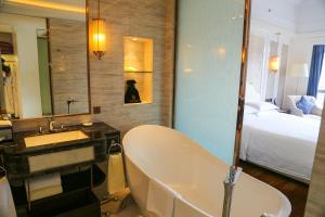 宝安深圳登喜路国际大酒店(深圳机场店)的带浴缸、水槽和床的浴室