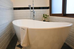 SanteaguedaVilla Toscana ValQuirico Lofts & Suites Hotel Boutique的带浴缸的浴室和窗户