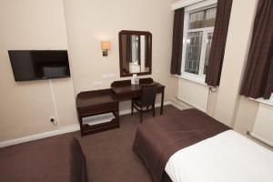 斯旺西海豚SA1酒店的酒店客房带一张床、一张书桌和一面镜子