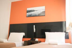 奥尔莫克Ialodge的一间卧室设有两张床,配有橙色和黑色床头板