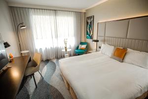 悉尼北岸普特希尔酒店的酒店客房设有一张大床和一张书桌。